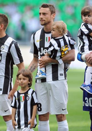 La Juve festeggia lo scudetto in casa contro il Cagliari e i bianconeri scendono in campo con i loro bambini . Ecco Claudio Marchisio sul prato dello Juventus Stadium. Ansa